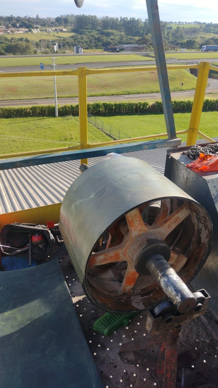 Rolo sendo revestido na plataforma de uma planta industrial, com as ferramentas da equipe da Comang ao lado